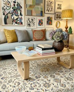 Cream hand-knotted Kashan Persian carpet with an intricate central medallion design, styled on the floor of a lounge room.