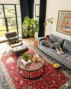 Hand-knotted red Tabriz Persian carpet with an intricate traditional pattern, styled on the floor of a lounge.